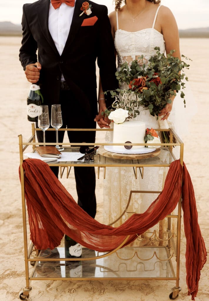bride and groom with cake at the dry lake bed