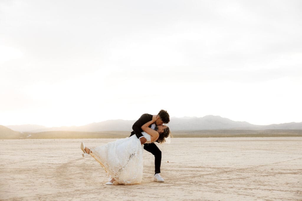 bride and groom dip kissing at the dry lake bed