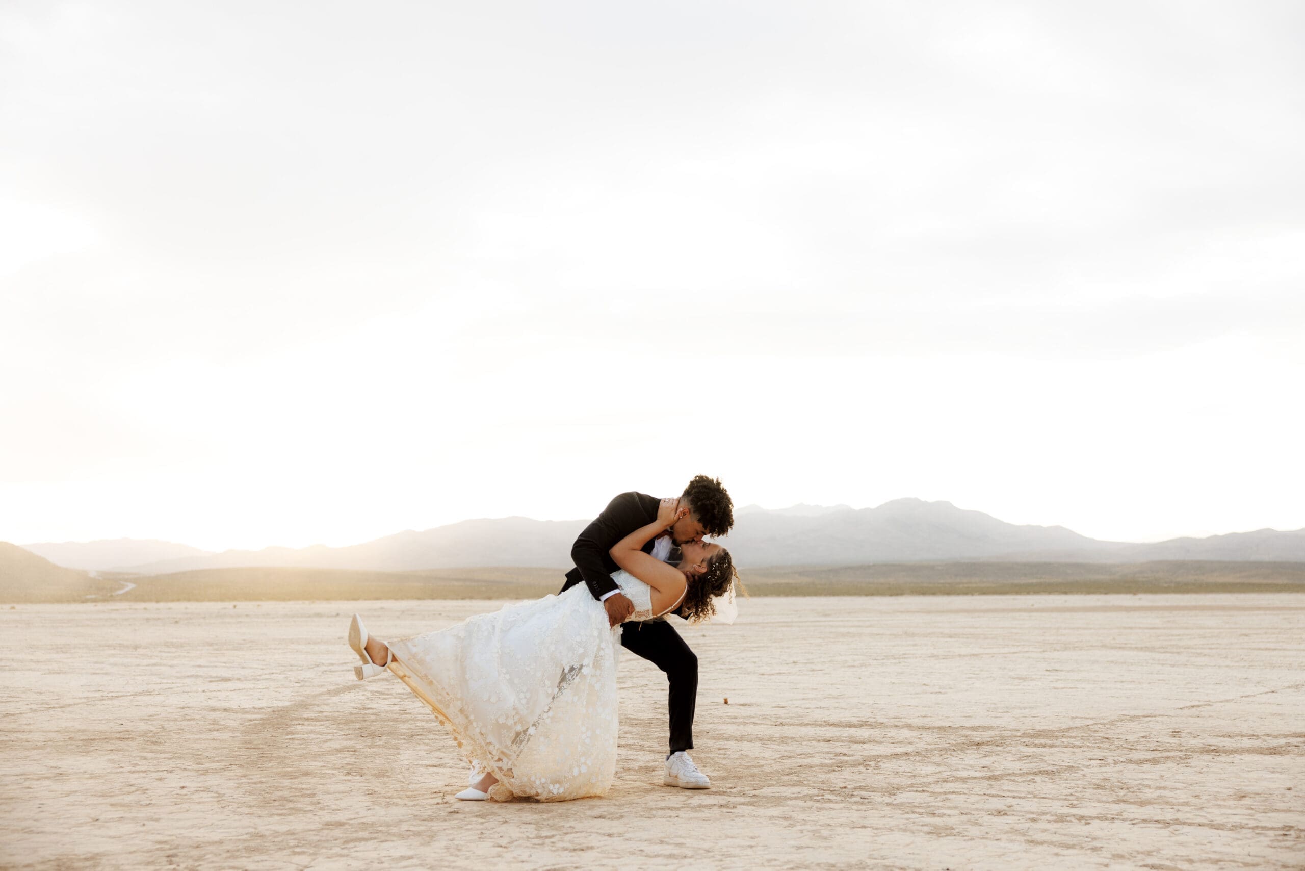 bride and groom dip kissing at the dry lake bed