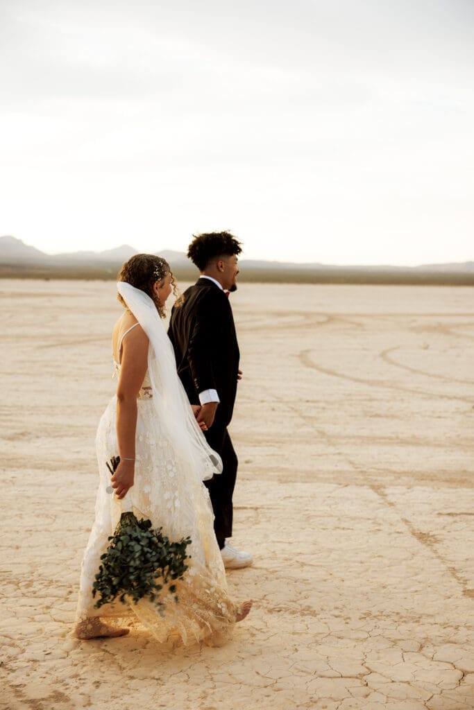 bride and groom walking on the dry lake bed