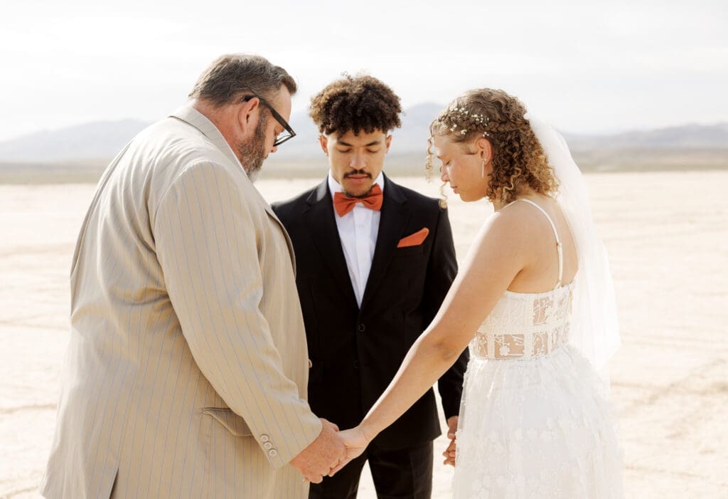 group of three praying before wedding ceremony