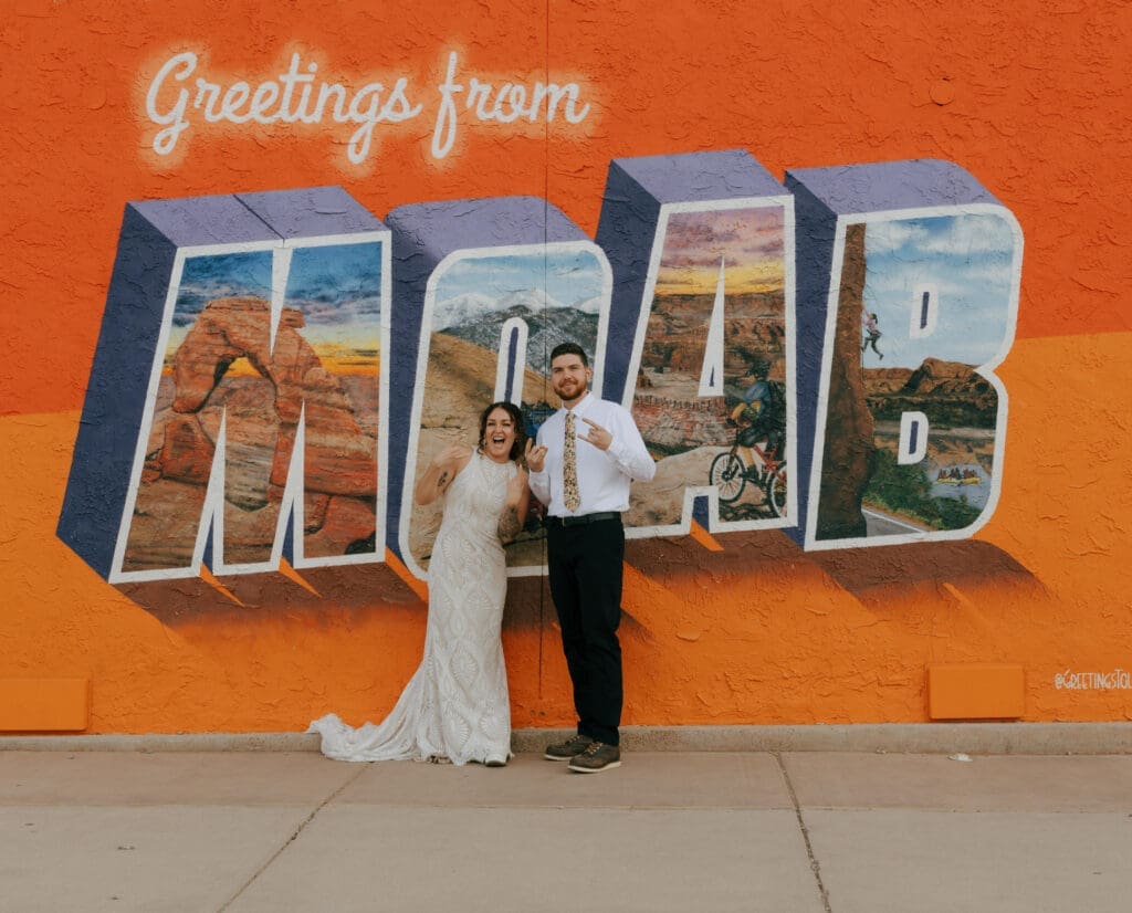 couple in front of the moab sign