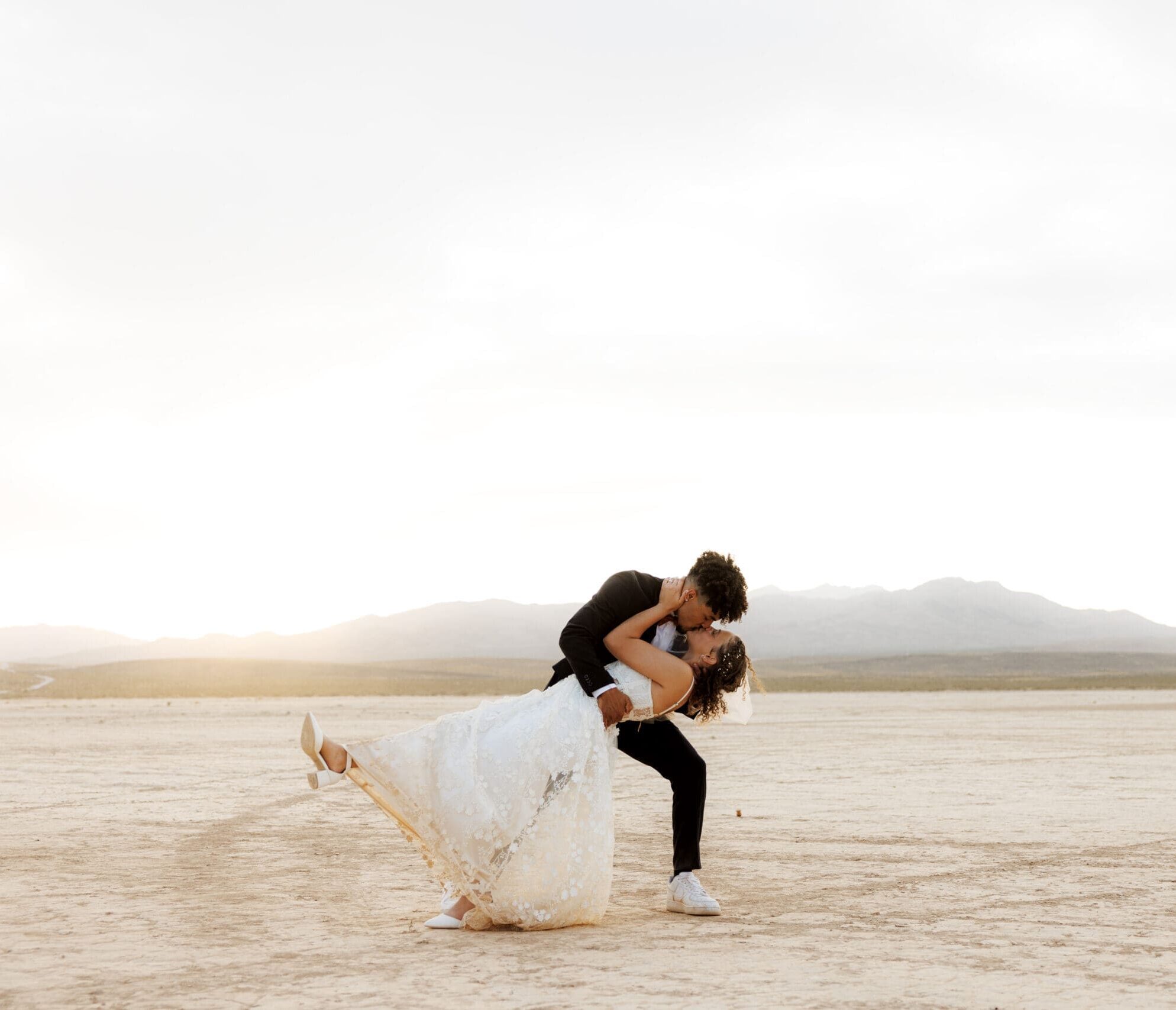 bride and groom dip kissing at the dry lake bed