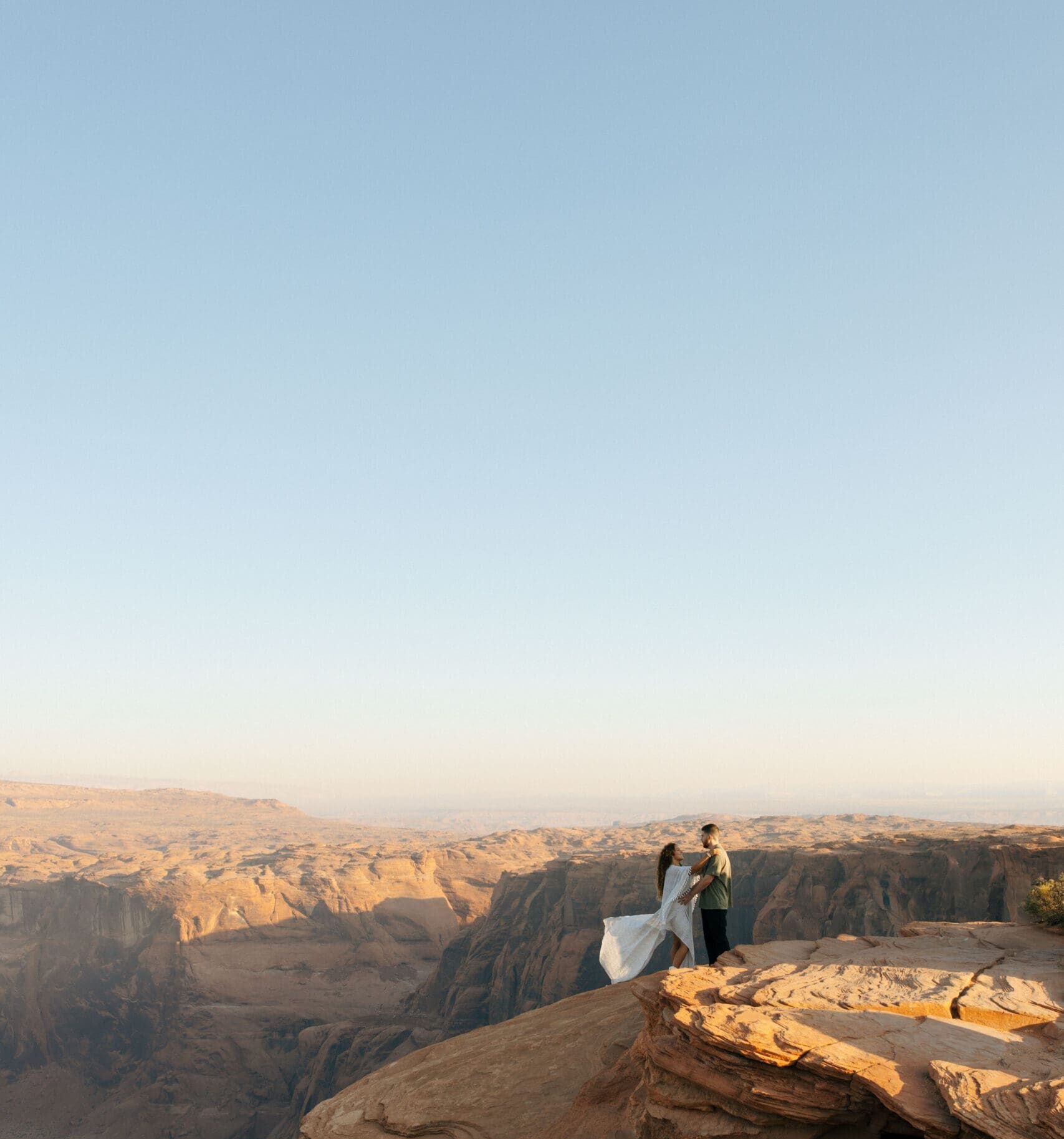 bride and groom standing on a cliff