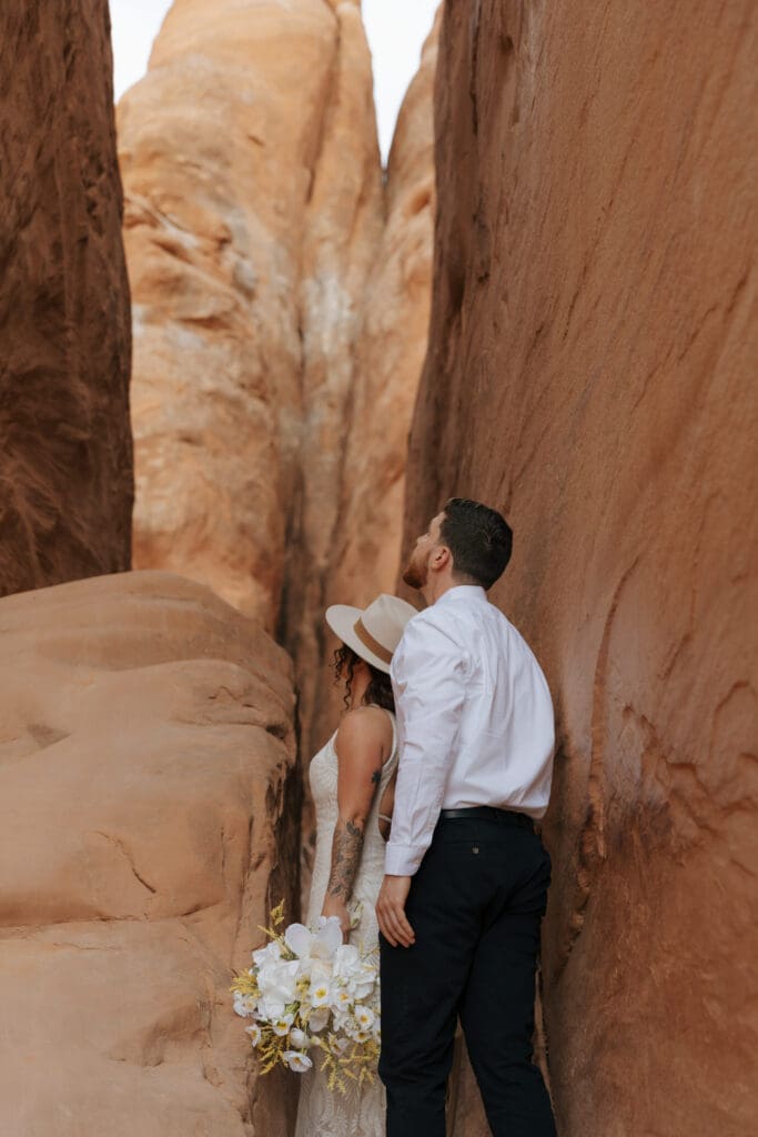 couple looking up in slot canyon