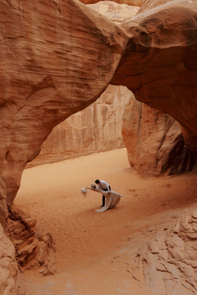 couple kissing under natural arch