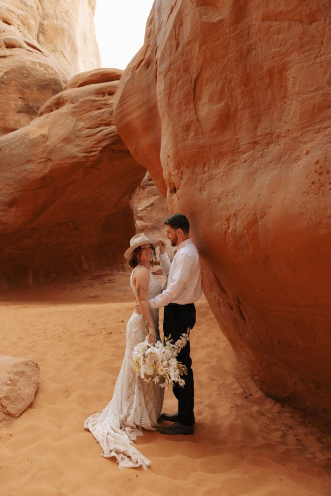 couple in between red rocks