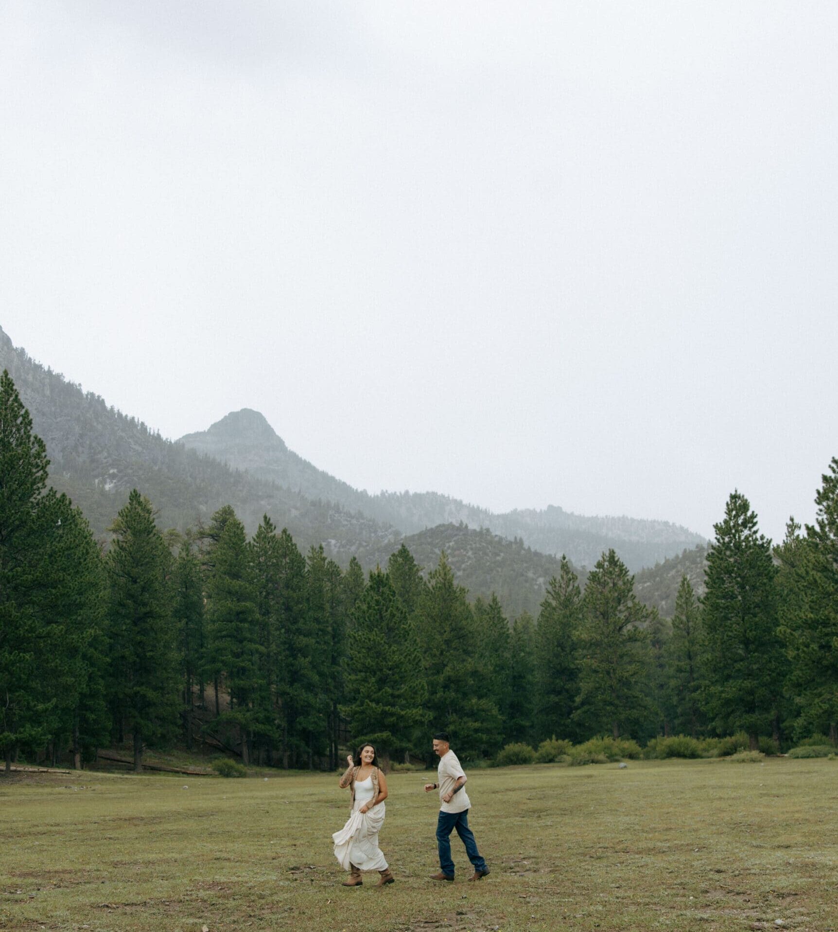 couple playing tag in forrest during their rainy mt charleston couples session