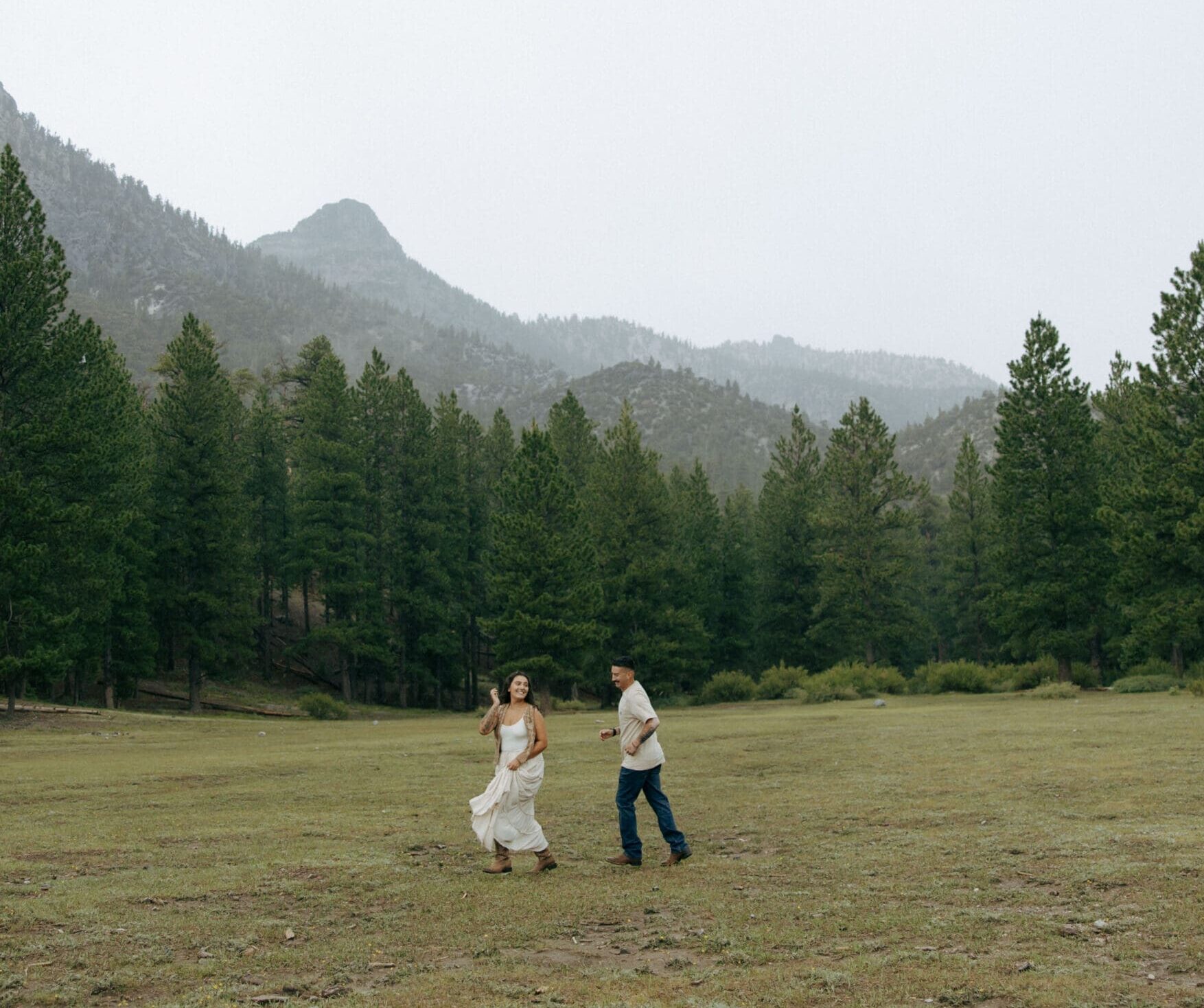 couple playing tag in forrest during their rainy mt charleston couples session