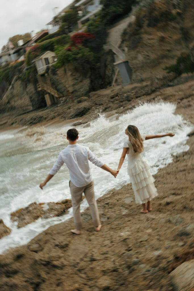 couple embracing the ocean waves crashing on the cliff