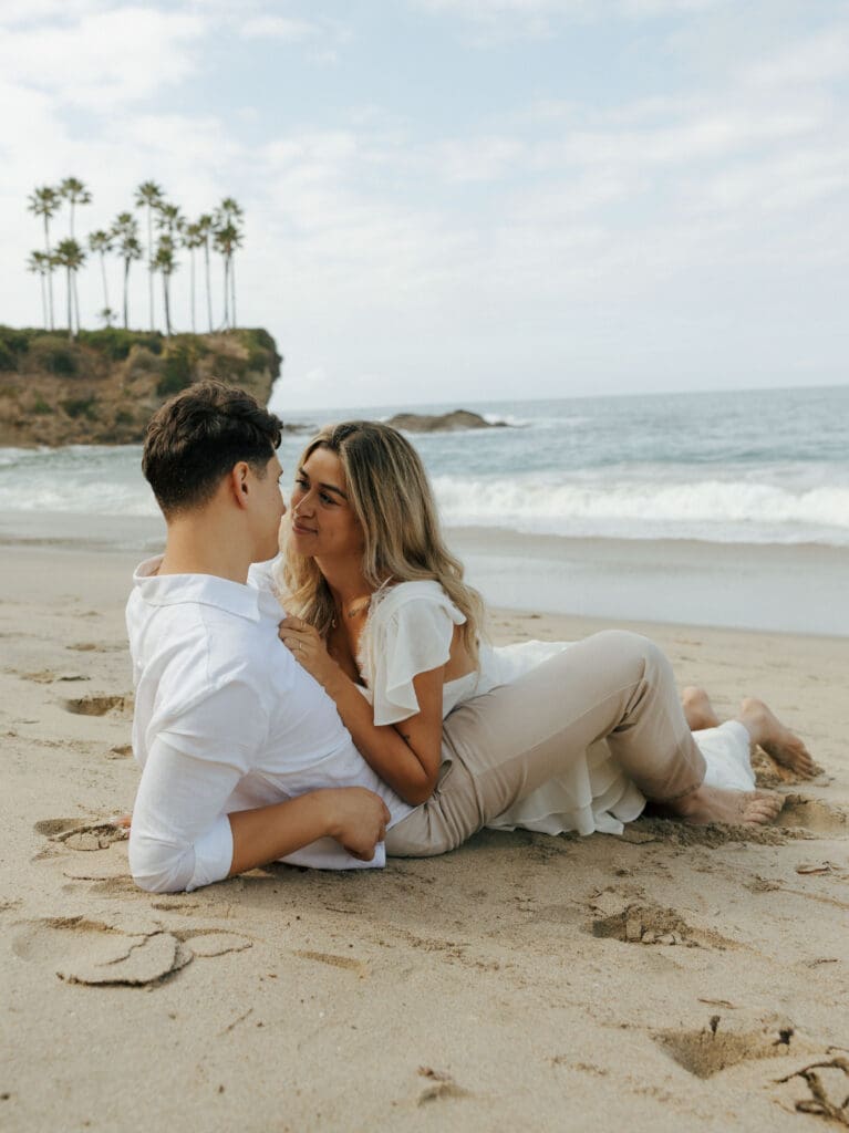 couple laying down at the beach for their laguna beach photoshoot