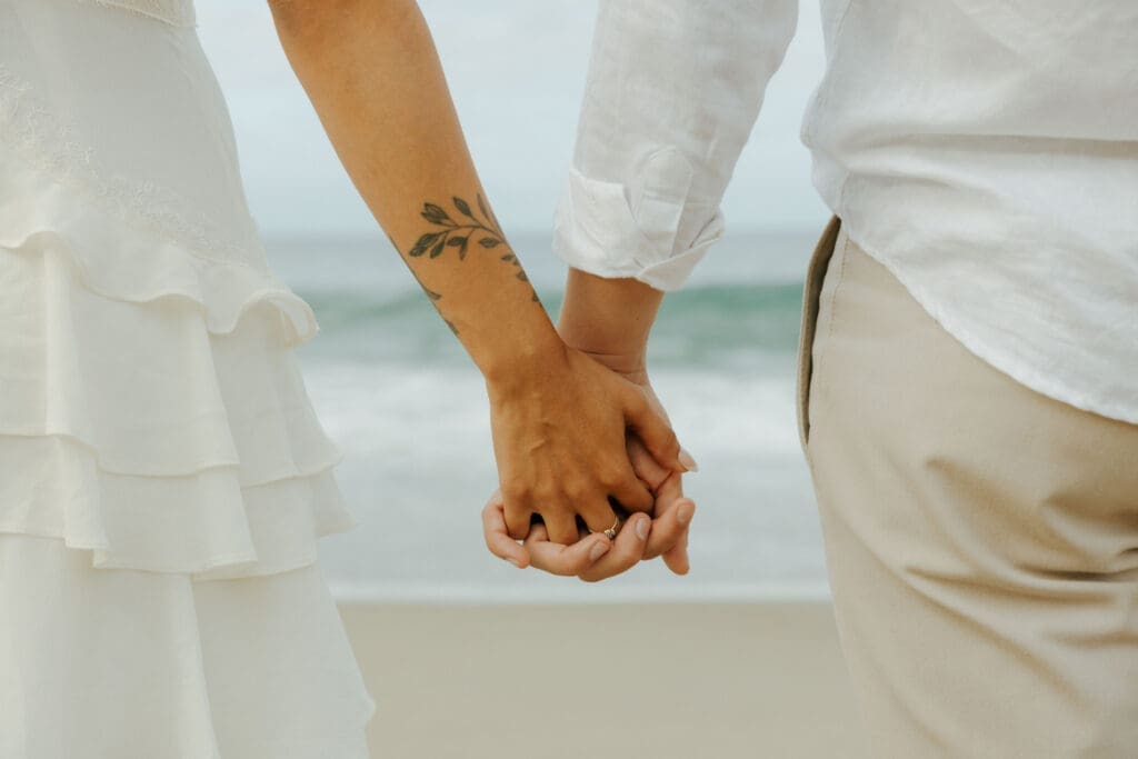 couple holding hands at crescent bay beach for their laguna beach photoshoot