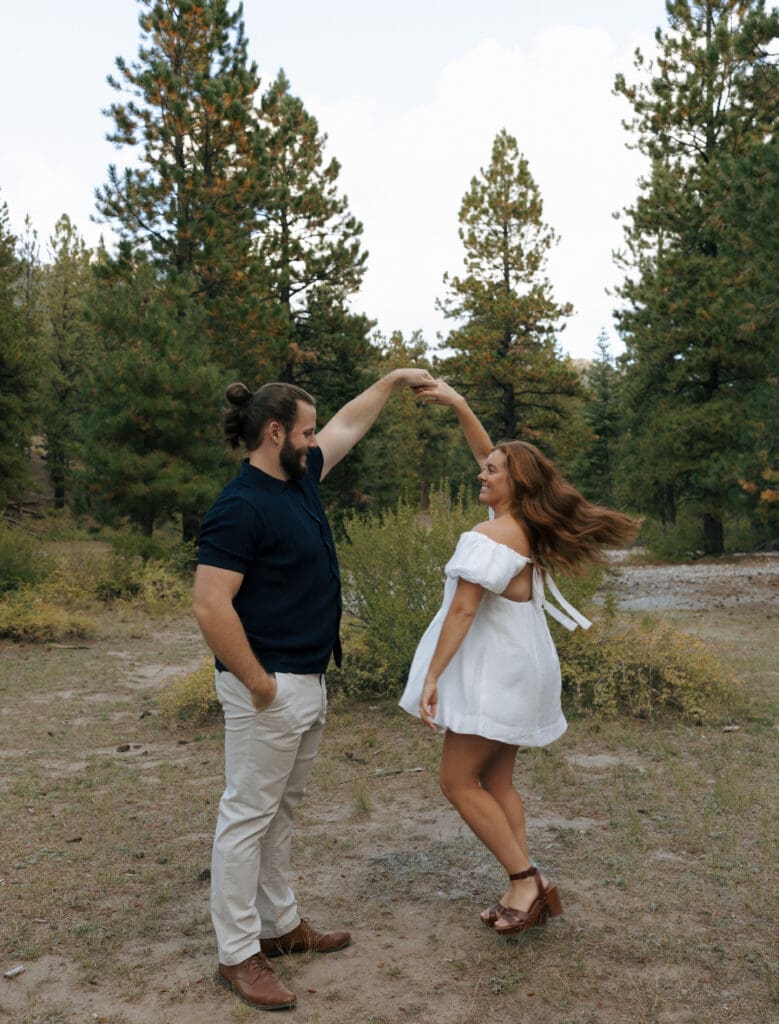 guy spinning girl in the forest