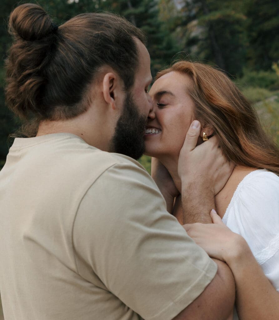 man holding his fiancés face gently kissing