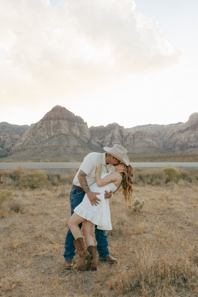 couple posing for engagement photos in red rock desert