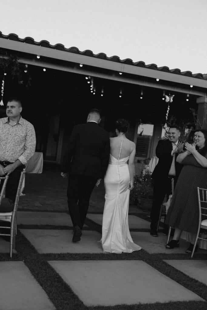 bride and groom holding hands walking down the aisle