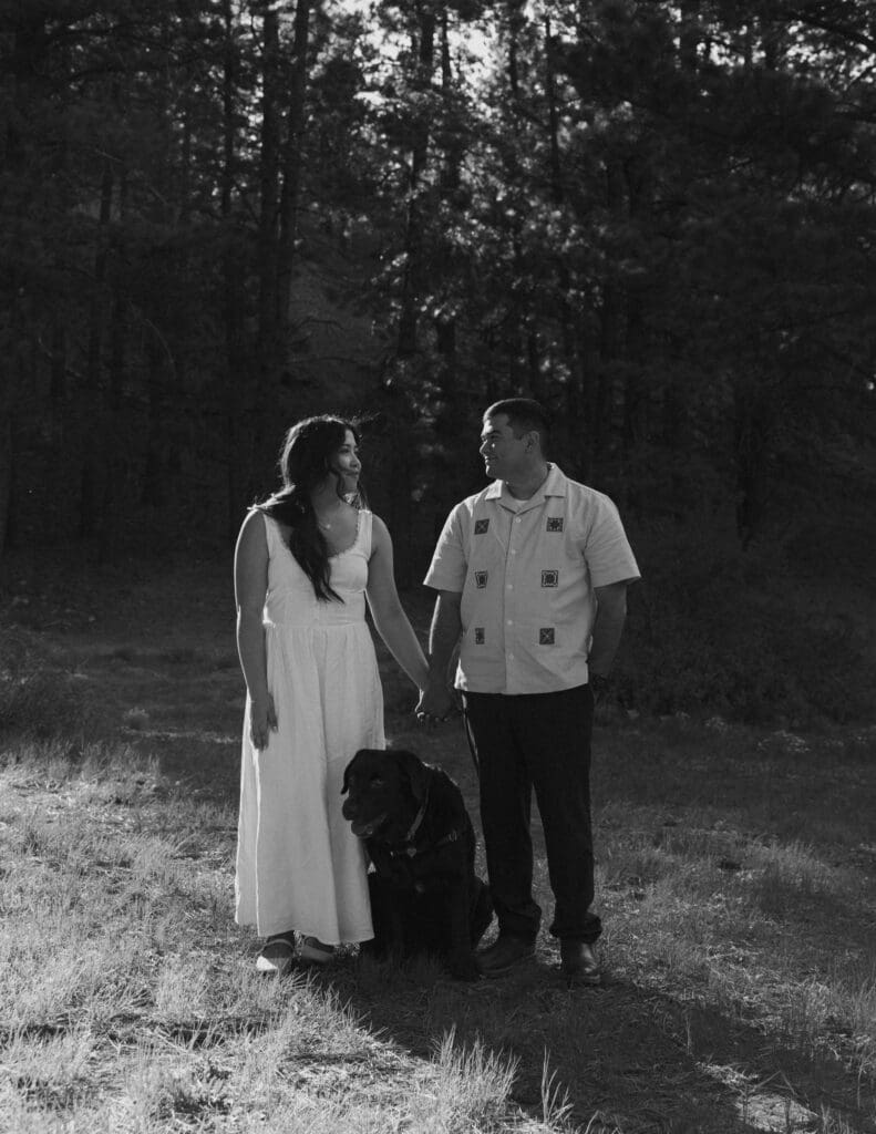 couple holding hands with their dog between them in mt charleston