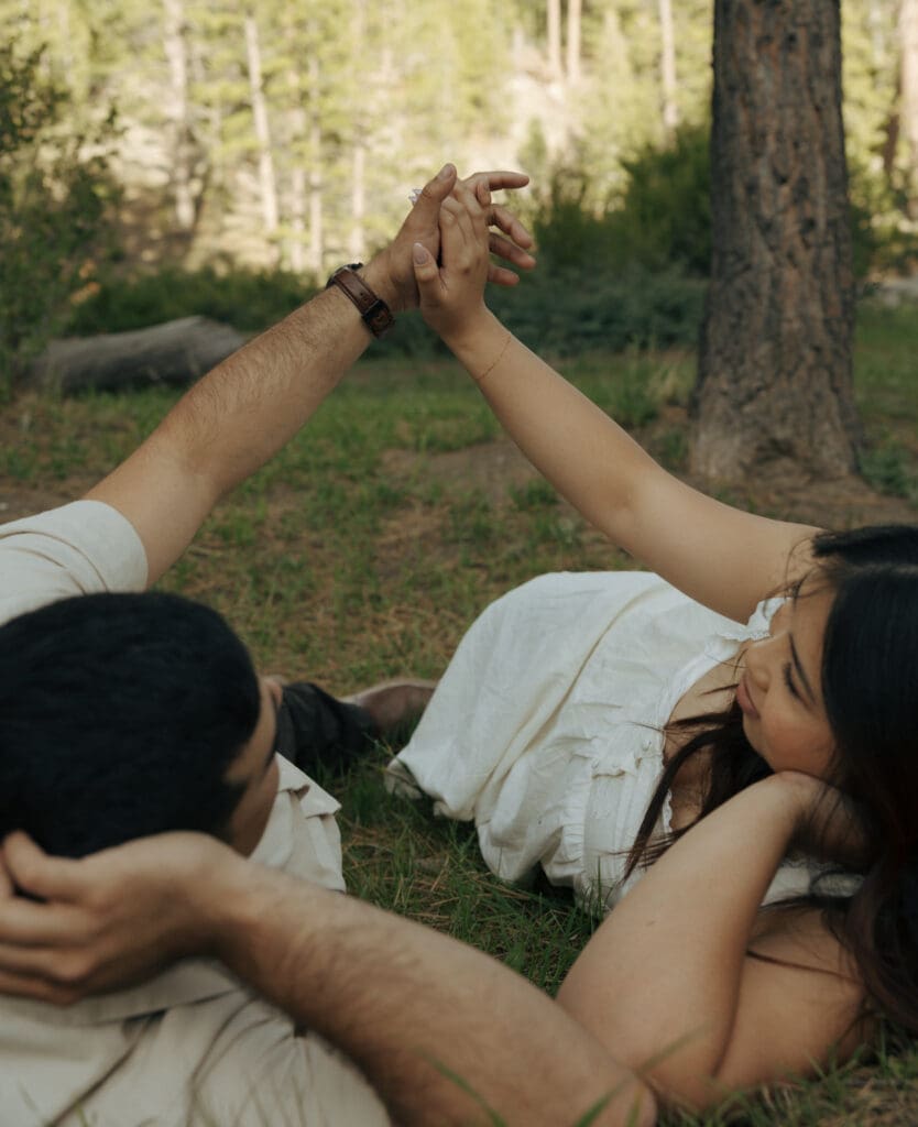 couple laying at lee meadow holding hands in las vegas