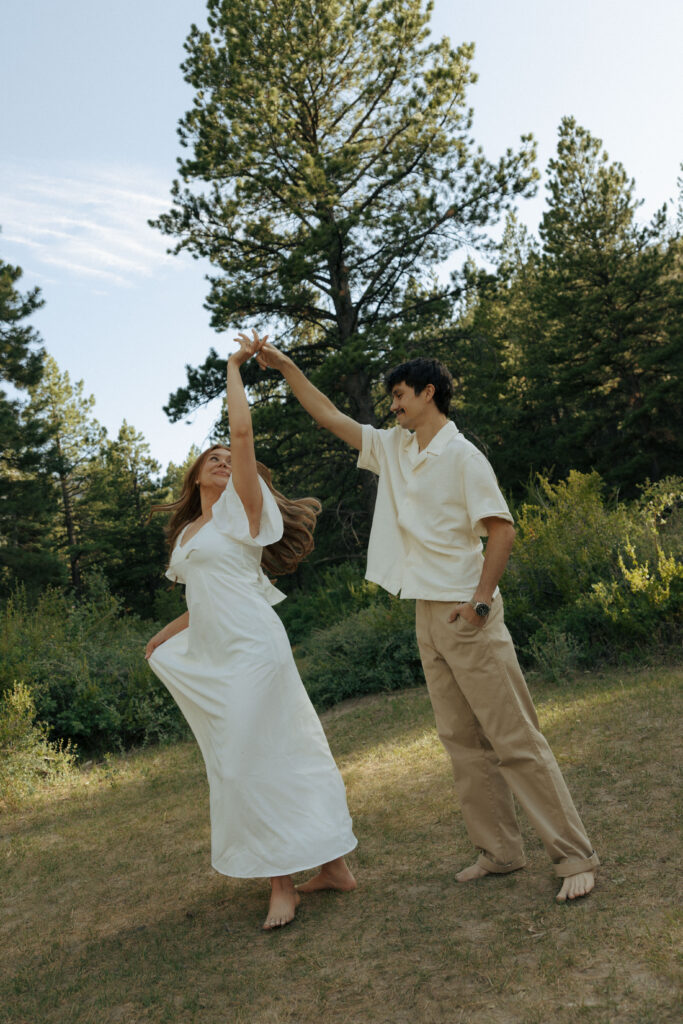 man spinning woman during their engagement photos at lee meadows
