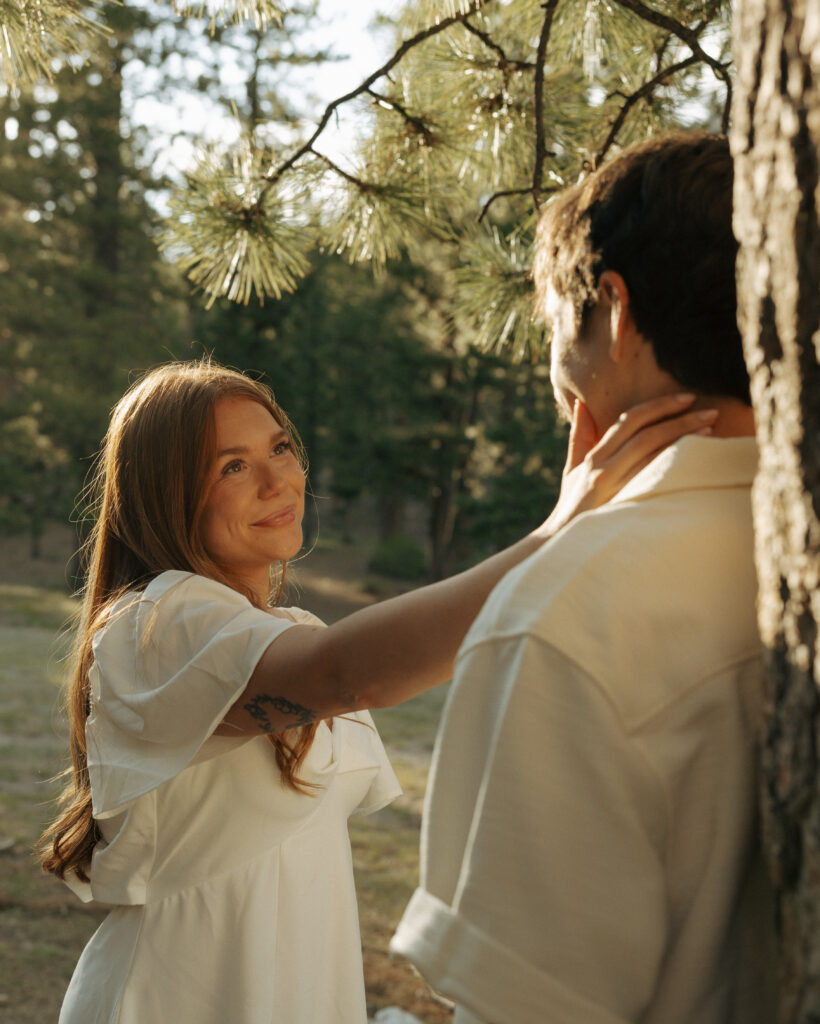 man leaning on tree woman caressing his face with soft sunlight at lee meadows
