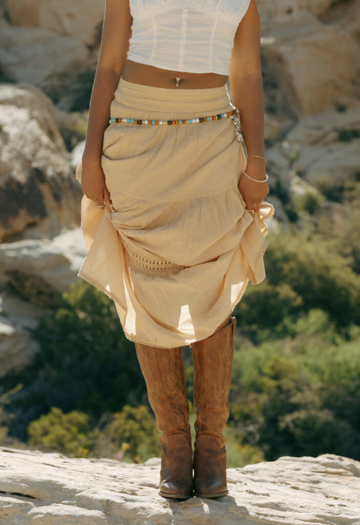 woman holding up skirt to show cowgirl boots