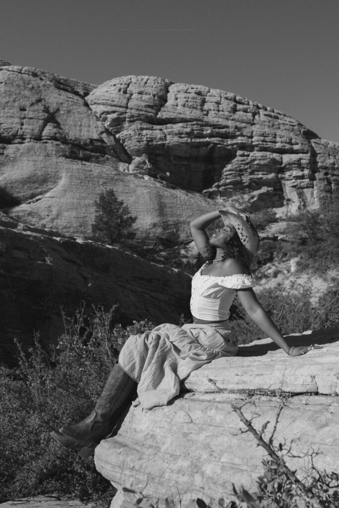 black and white image of woman leaning back on red rocks