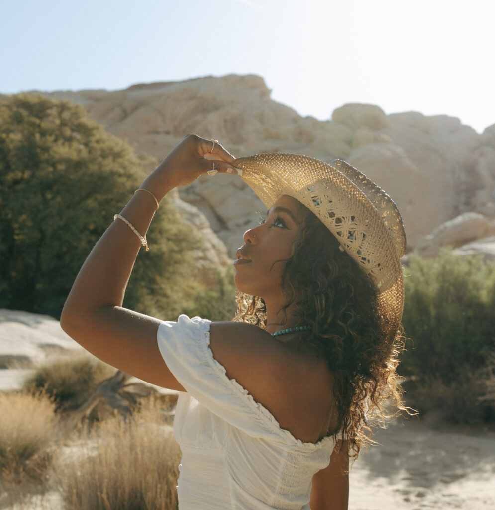 woman looking to the sky holding cowboy hat in las vegas