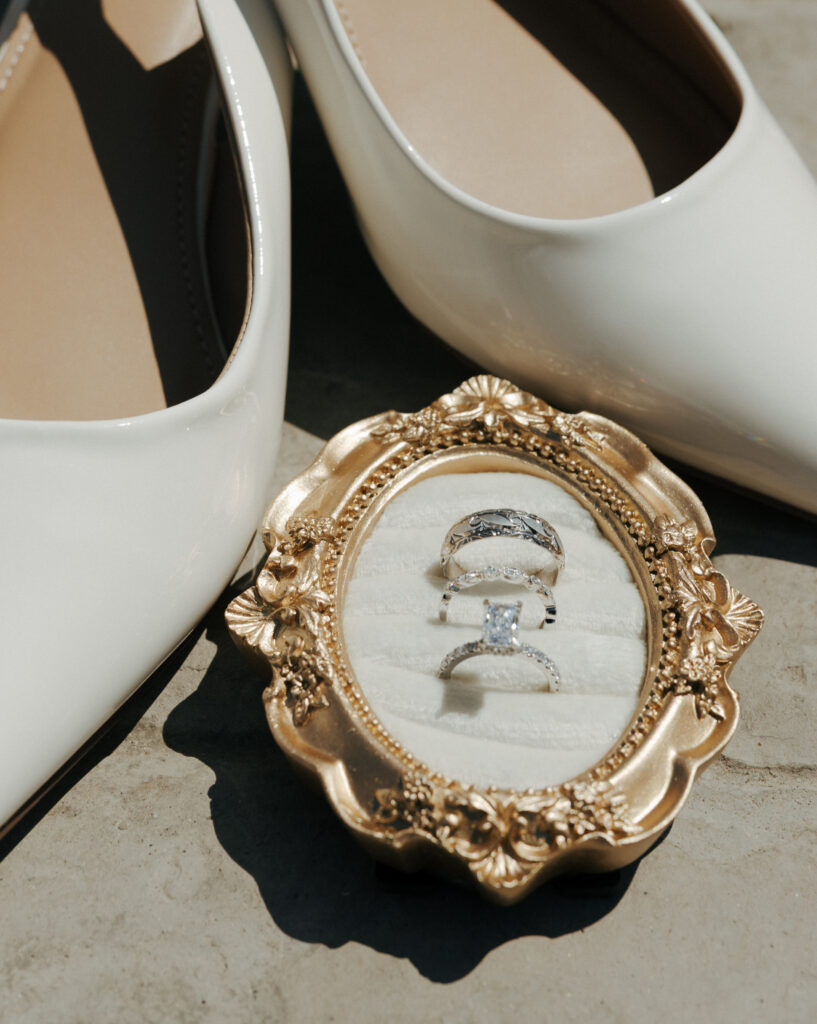 wedding rings in gold rustic frame between white heels