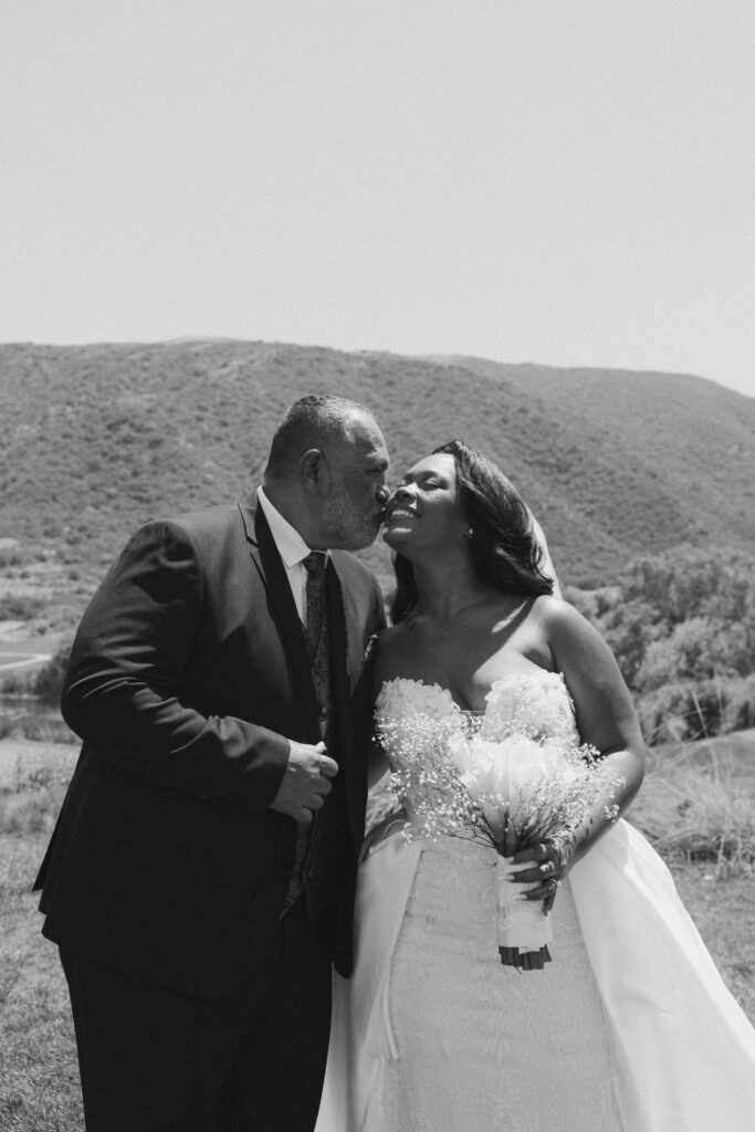 dad kissing bride on cheek