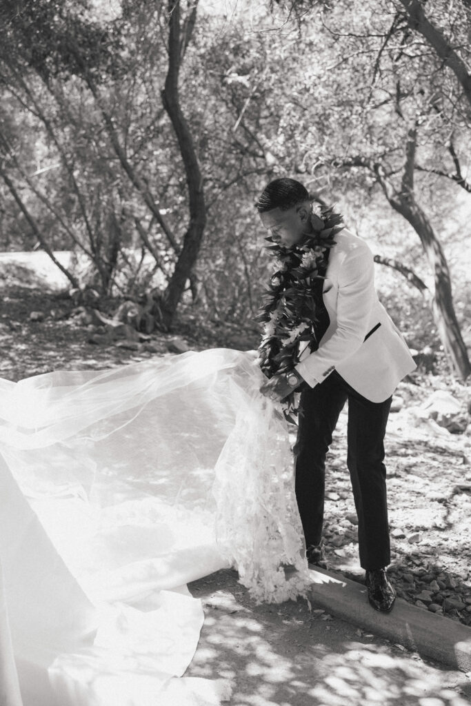 groom fixing brides dress
