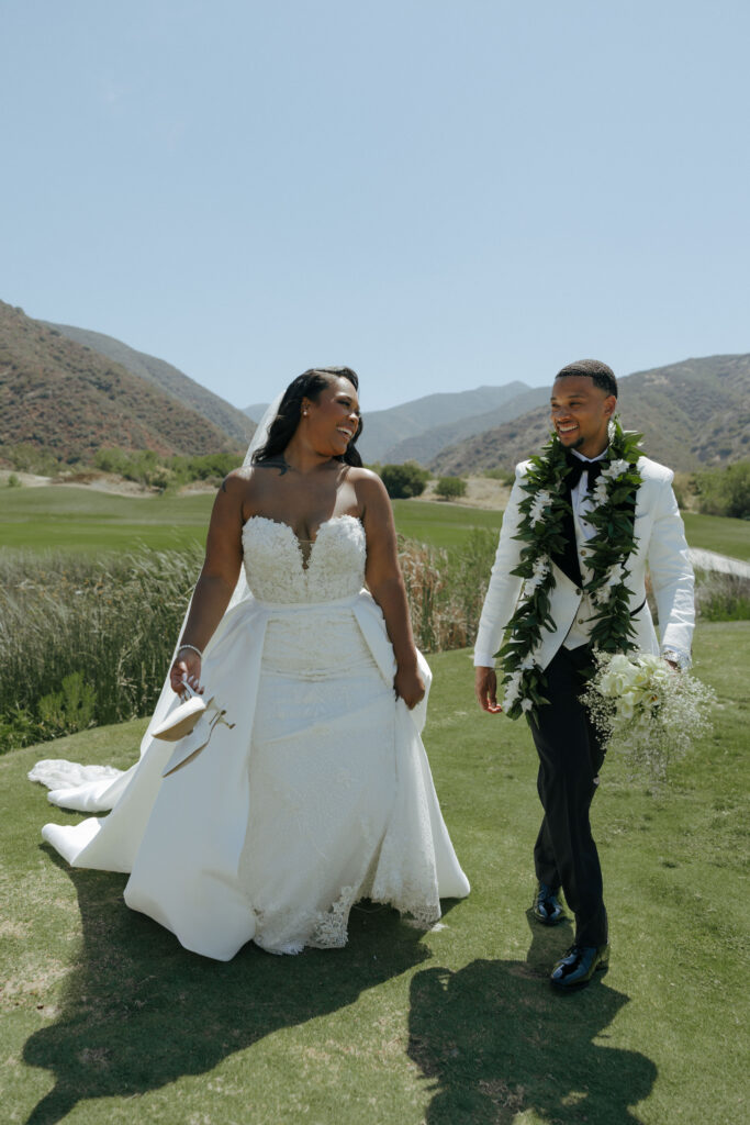 bride and groom laughing on golf course