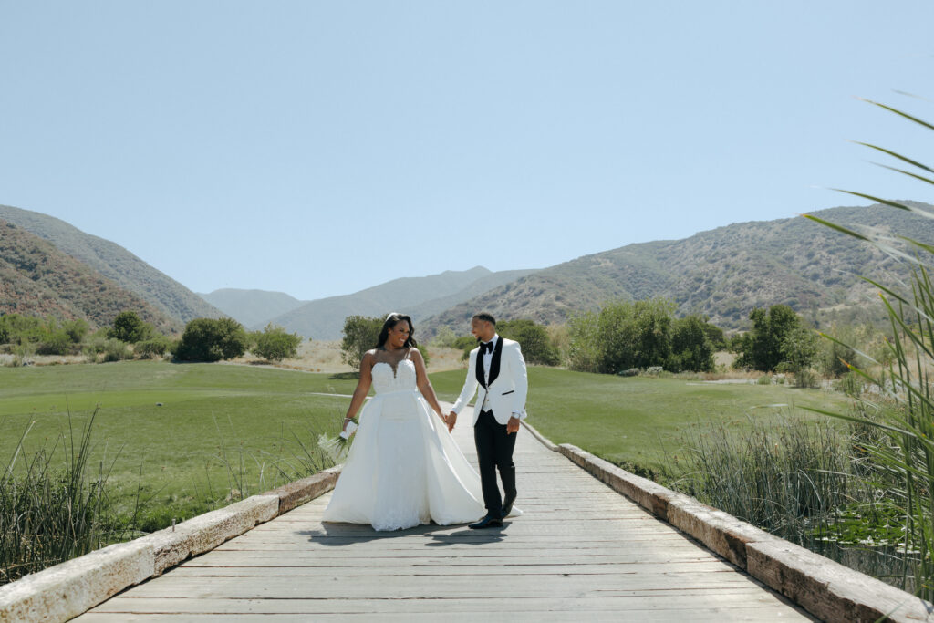 bride and groom walking on bridge at eagle glen golf club