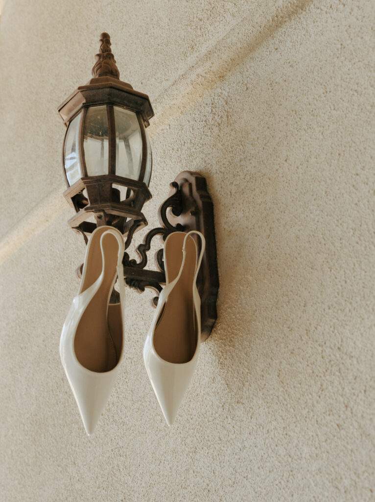 white wedding heels hanging from light fixture