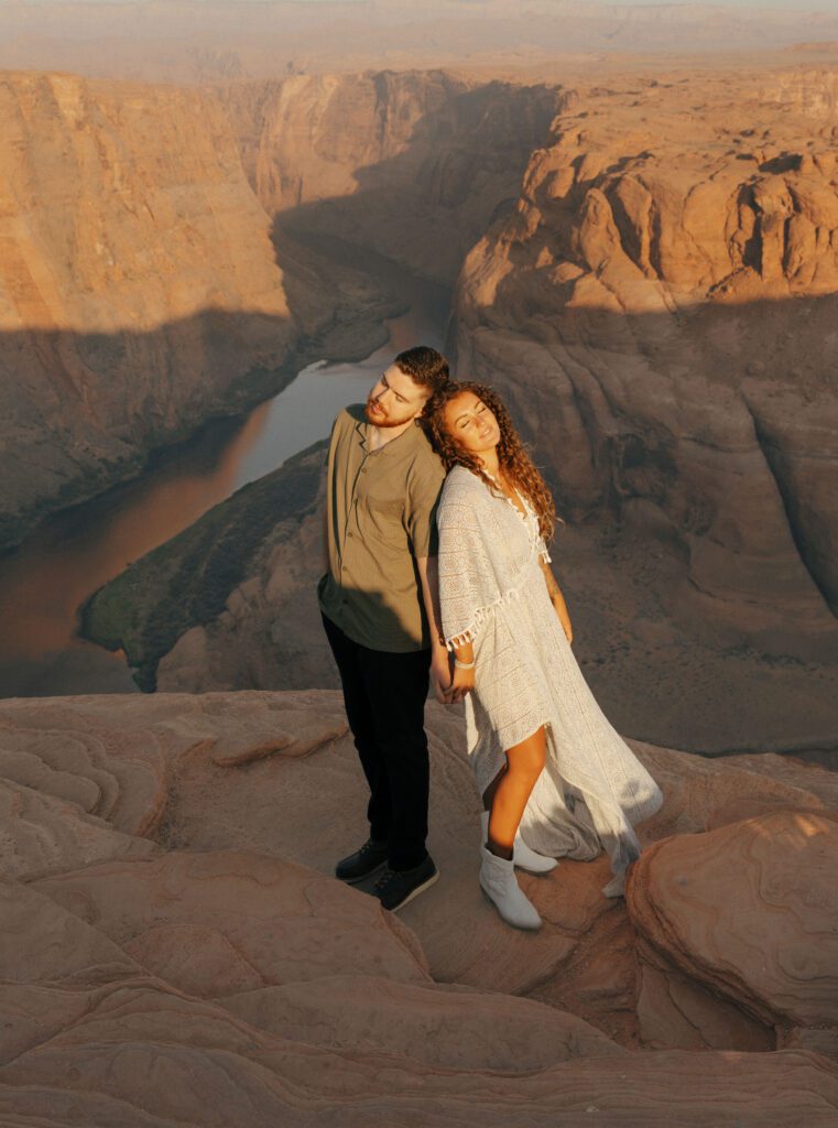 couple holding hands standing back to back