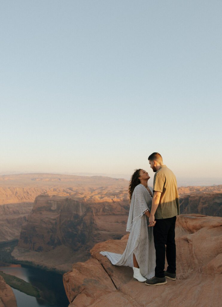 couple kissing on cliff at horseshoe bend couples session