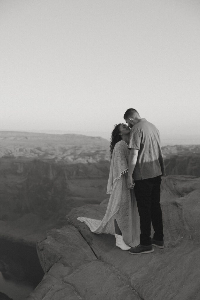 couple kissing on cliff at horseshoe bend couples session