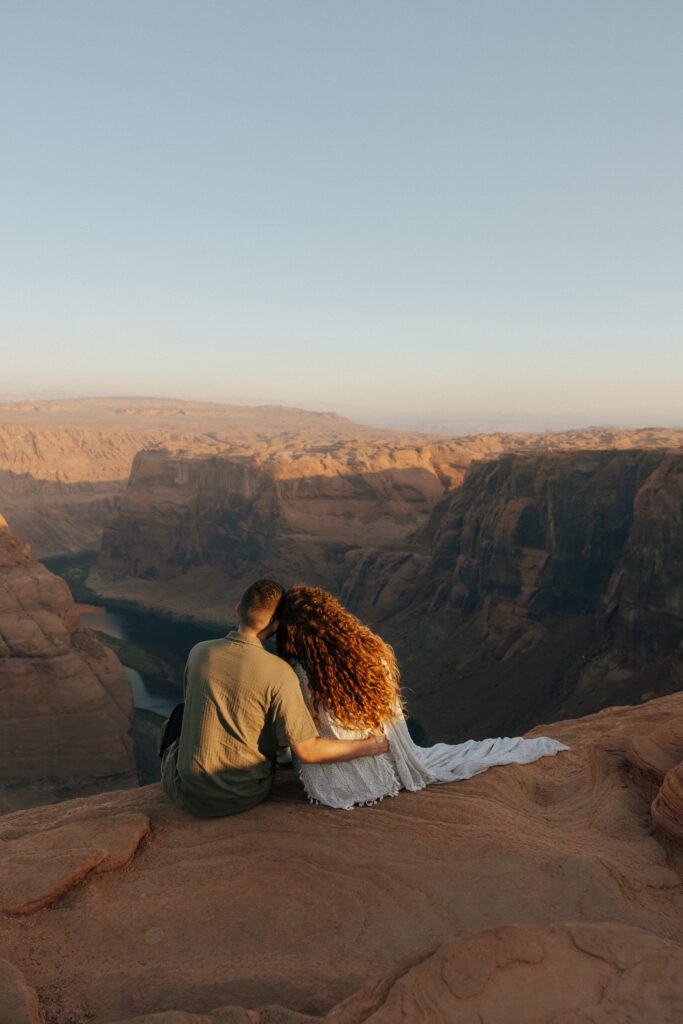 couple sitting on the edge of a cliff