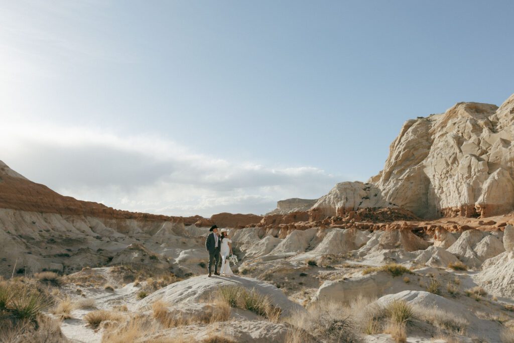 bride and groom standing on a rock at hoodoos toadstool in kanab elopement guide