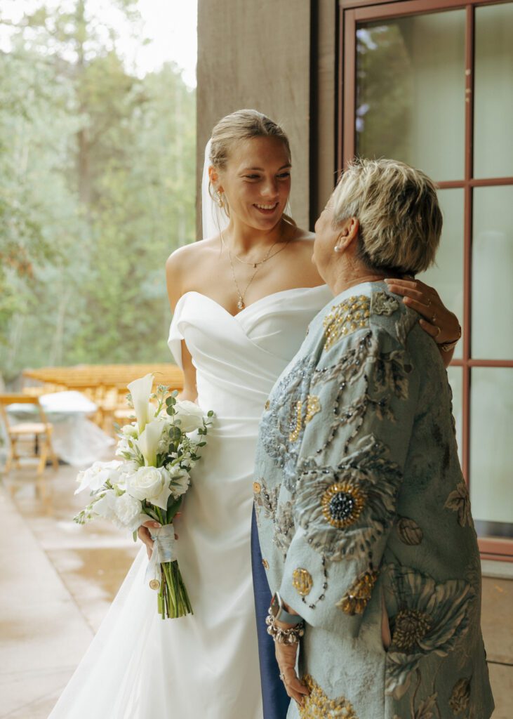 bride and mom smiling at each other