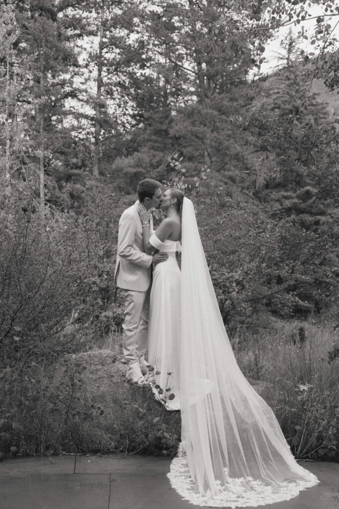 bride and groom kissing on a rock during their micro wedding at donovan pavilion