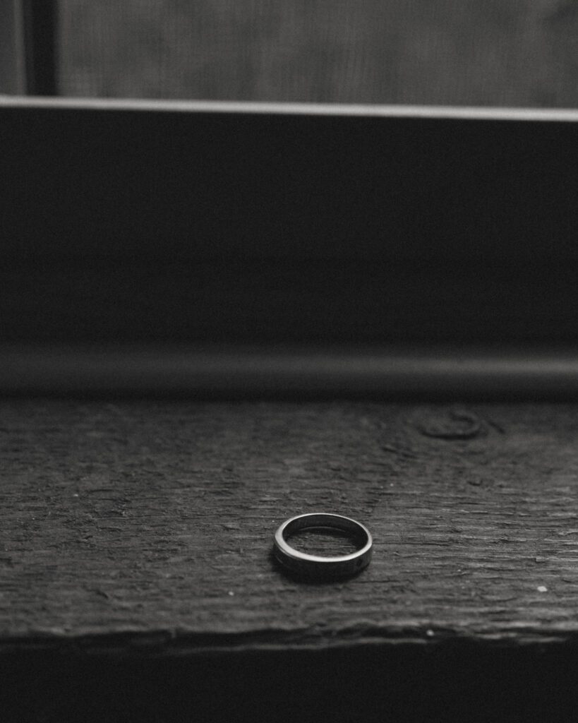 black and white image of groomsmen ring sitting on window ledge