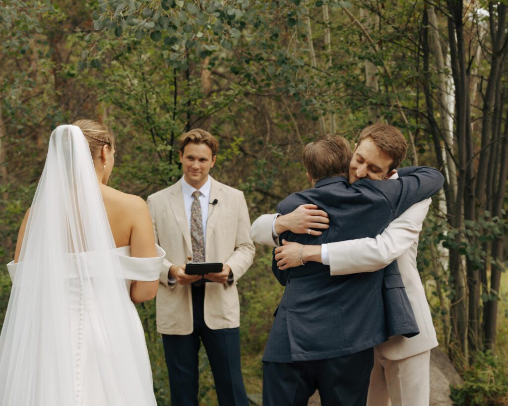 dad of the bride hugging the groom at the aisle