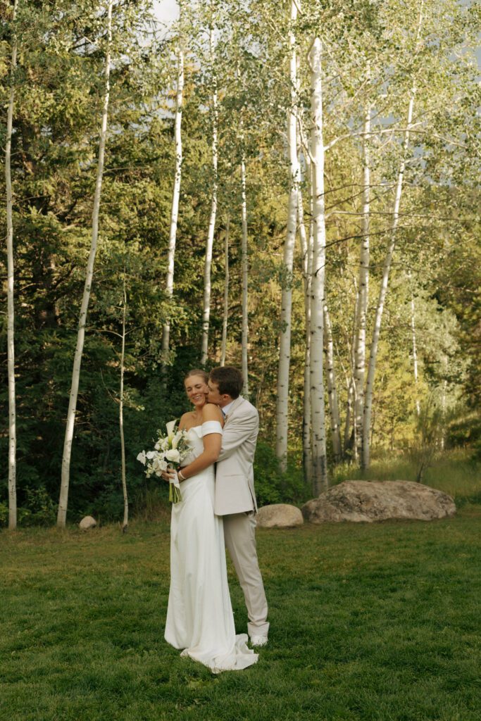 groom kissing the brides cheek during bridal portraits