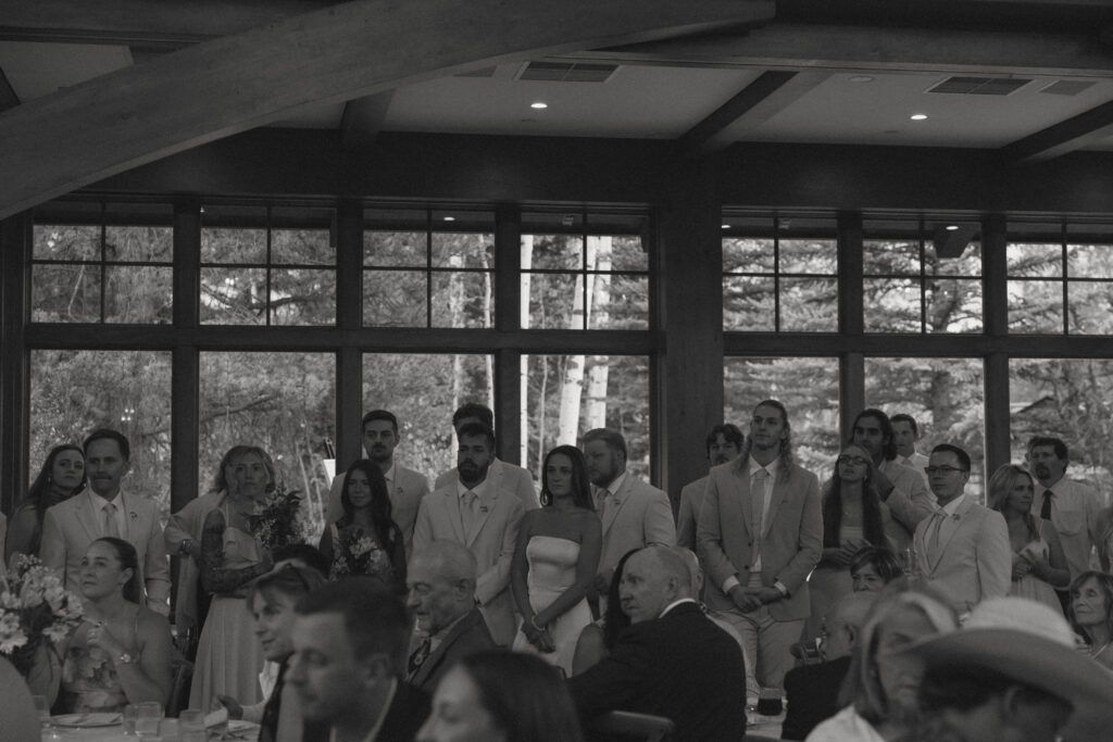 black and white image of guests listening to wedding speeches